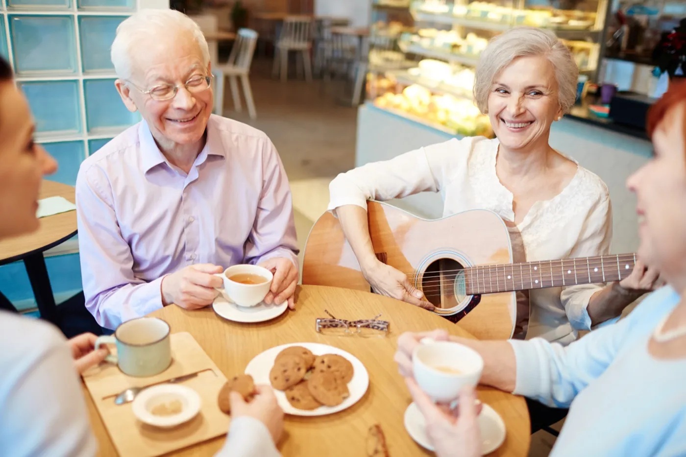 Seniorinnen und Senioren trinken Kaffee und musizieren