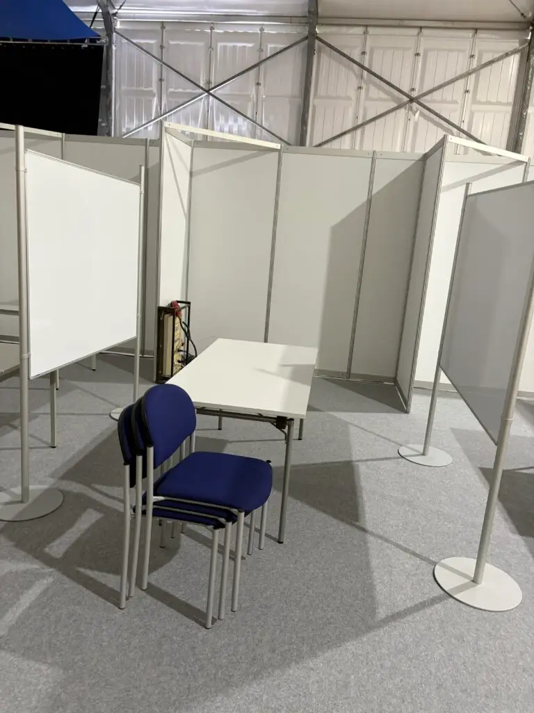 Noch ungestalteter Messestand der AWO Stadtverband Löhne e.V. mit weißen Stellwänden, Tisch und gestapelten Stühlen vor der Gewerbeschau 2026.