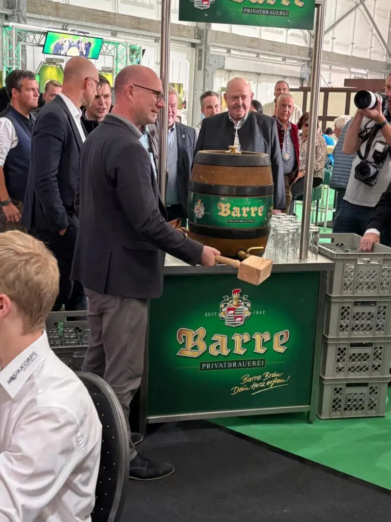 Fassanstich beim Löhner Oktoberfest 2026: Ein Mann hält einen Holzhammer am Bierfass, umgeben von Gästen und einem Fotografen.