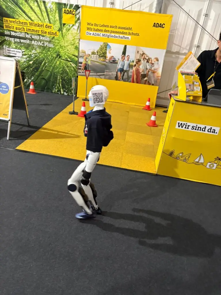 Ein humanoider Roboter vor dem gelben ADAC-Stand mit Verkehrskegeln auf der Löhner Gewerbeschau 2026.