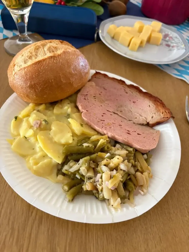 Teller mit Leberkäs, Kartoffelsalat, Bohnensalat und Semmel