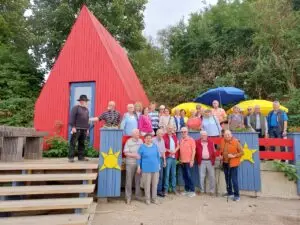Gruppenbild der AWO-Besuchergruppe vor dem roten Firmengebäude von Schormann Holzbau